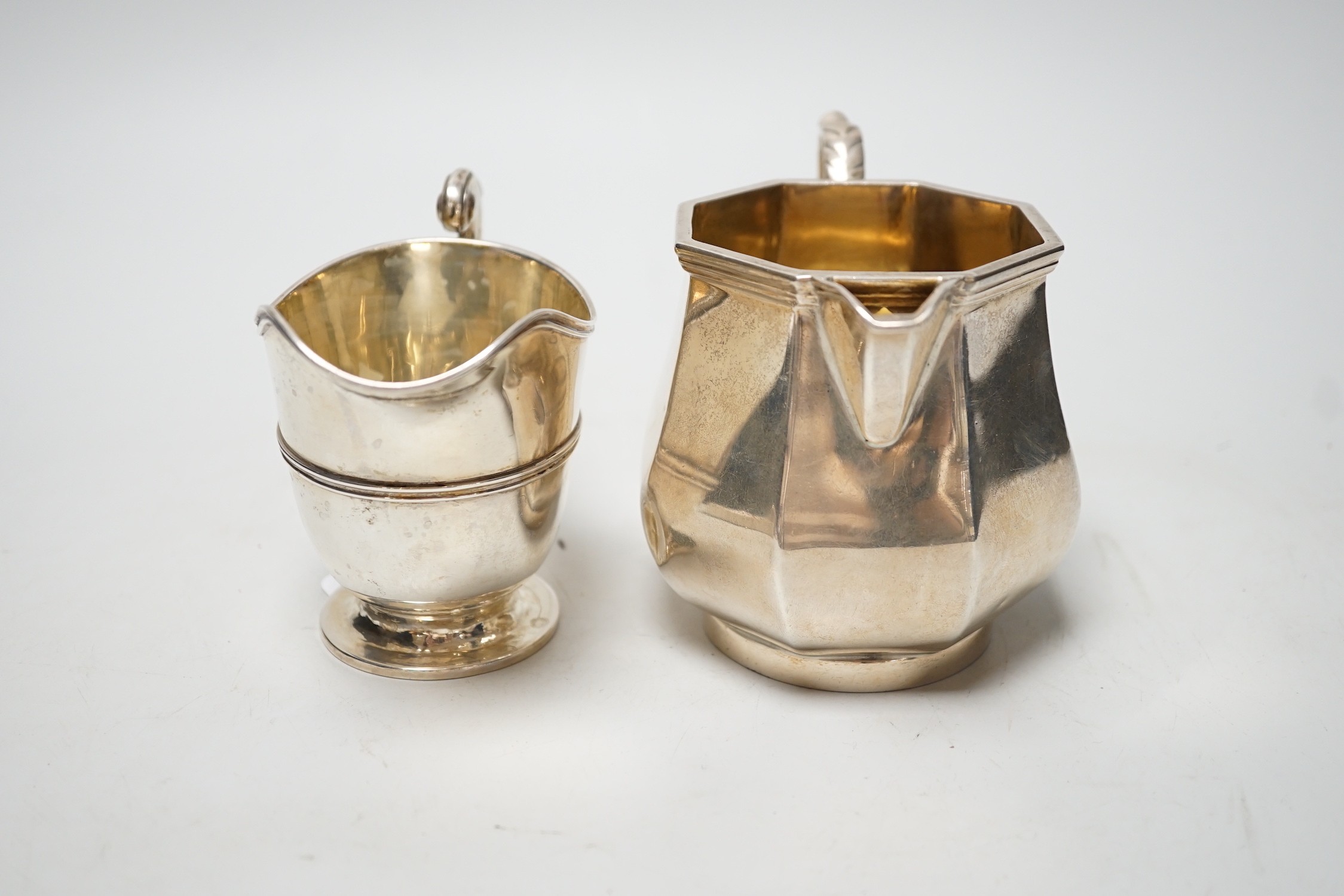 A George V panelled silver cream jug, by Elkington & Co, Birmingham, 1926, height 10cm and a late Victorian silver cream jug, London, 1899, 12.6oz.